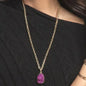 Gold chain necklace with purple druzy pendant worn over black cable knit sweater