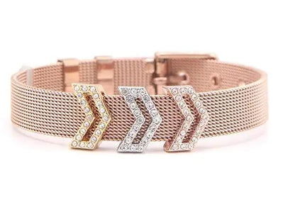 Rose gold mesh bracelet with gold, silver, and rose gold crystal arrow charms on white background