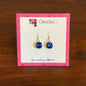 ClaudiaG brand blue faceted gemstone dangle earrings on pink patterned display card