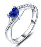 Silver ring with heart-shaped blue sapphire gemstone and diamond accents on split band