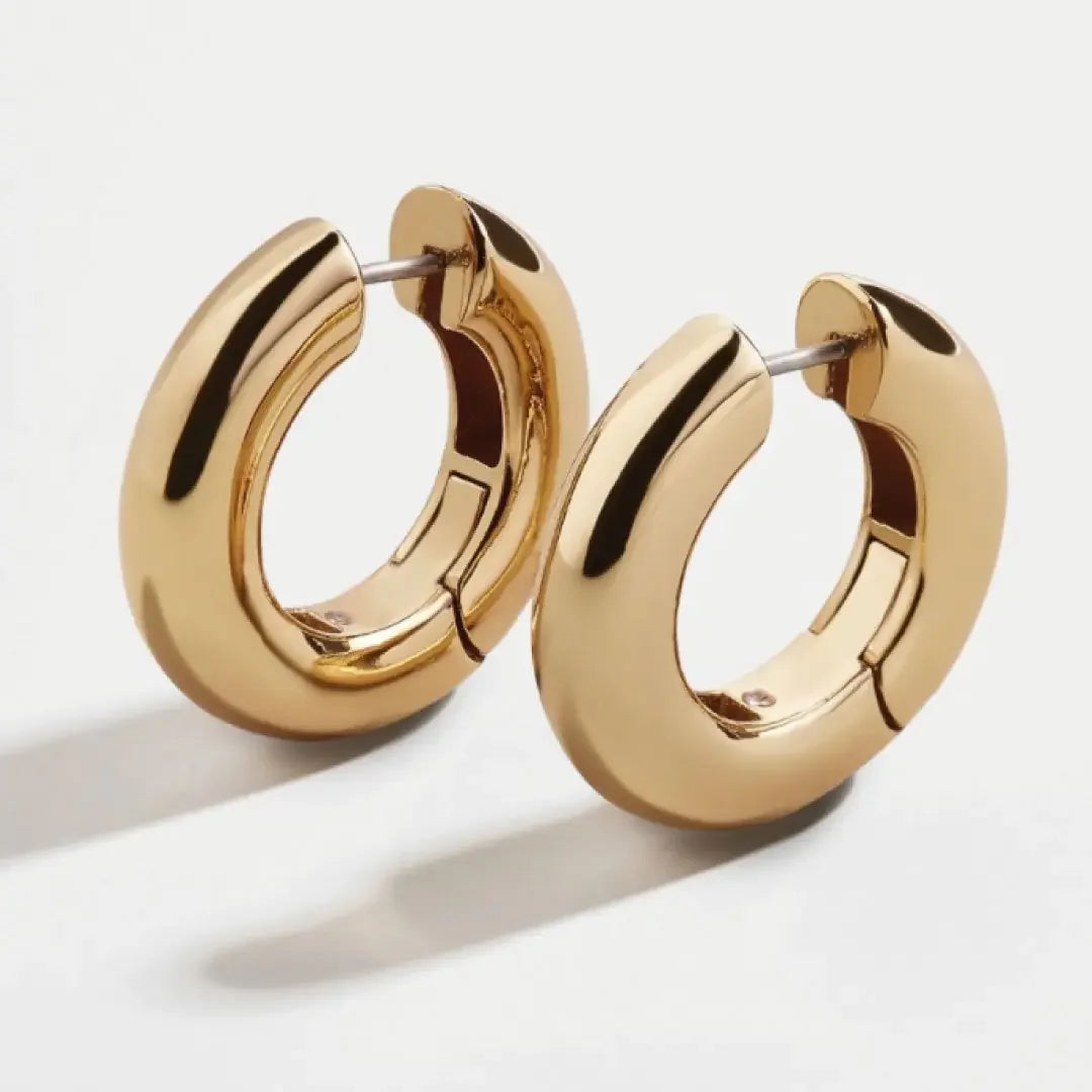 Pair of polished gold hoop earrings with smooth, thick design on white background