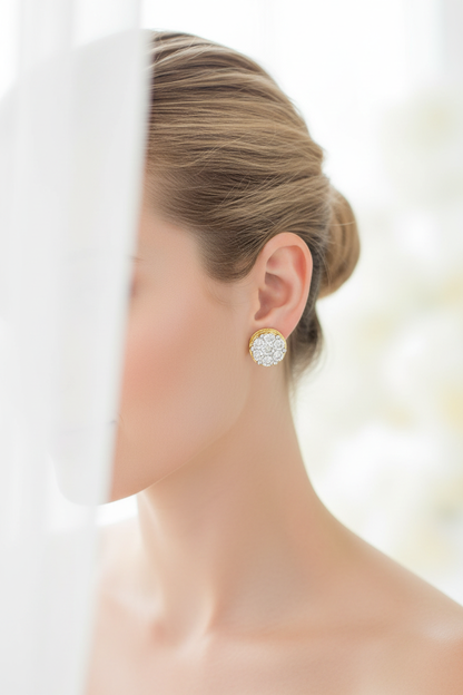 Elegant woman wearing gold and diamond cluster stud earrings with hair in a neat bun and a soft white background