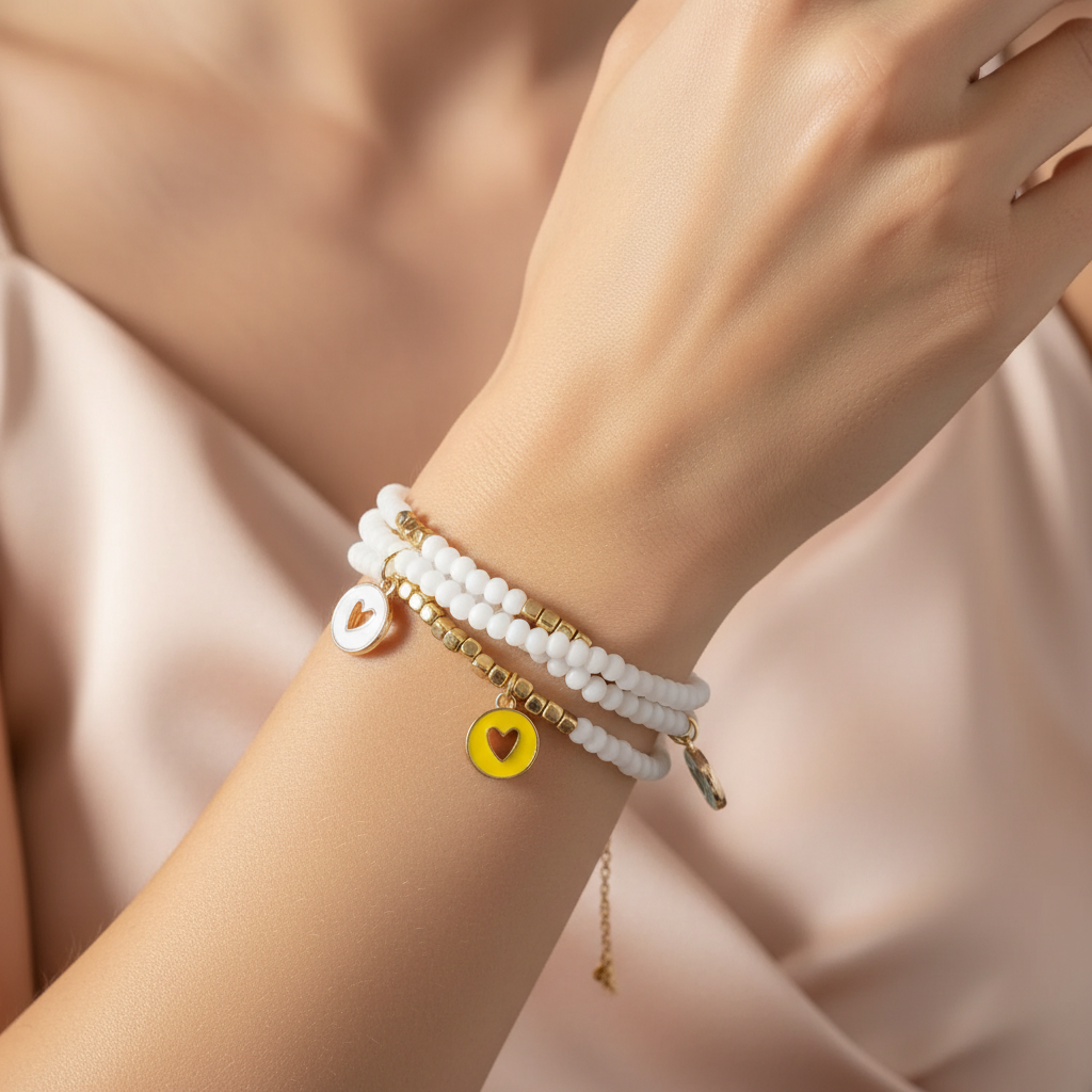 Elegant wrist adorned with white beaded gold-accented charm bracelets featuring heart pendants