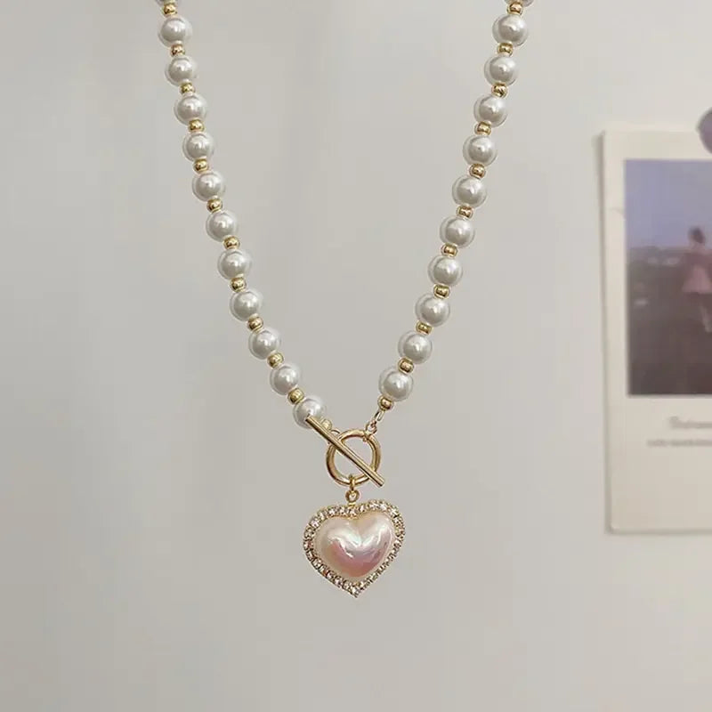 Elegant pearl necklace with gold beads and a heart-shaped pearl pendant embellished with crystals