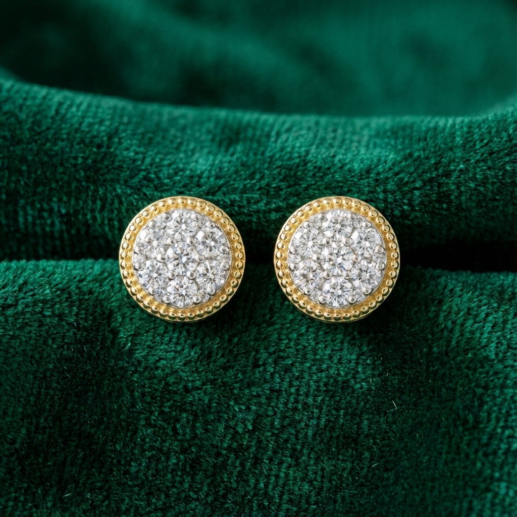 Round gold earrings with clustered white diamonds on textured green fabric background