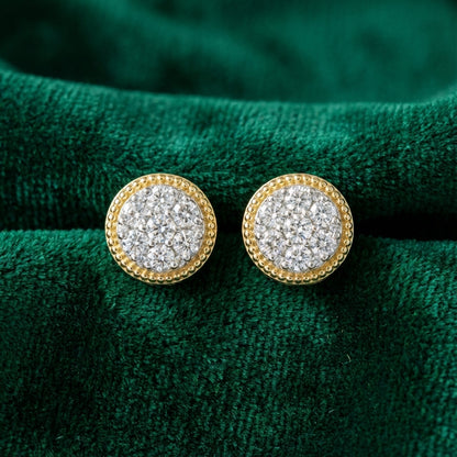 Round gold earrings with clustered white diamonds on textured green fabric background