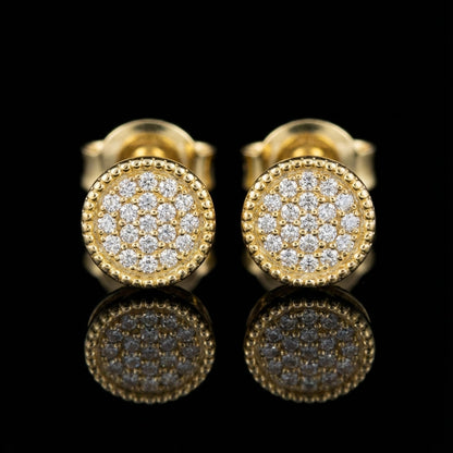 Pair of gold stud earrings with clustered round diamonds and beaded border on black background