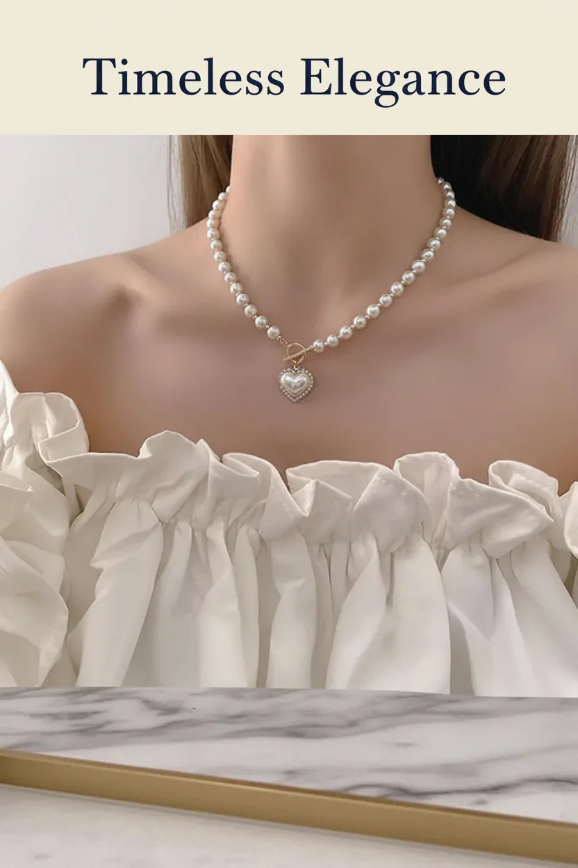 Pearl necklace with heart pendant worn on neck, paired with off-shoulder white ruffled dress, showcasing timeless elegance