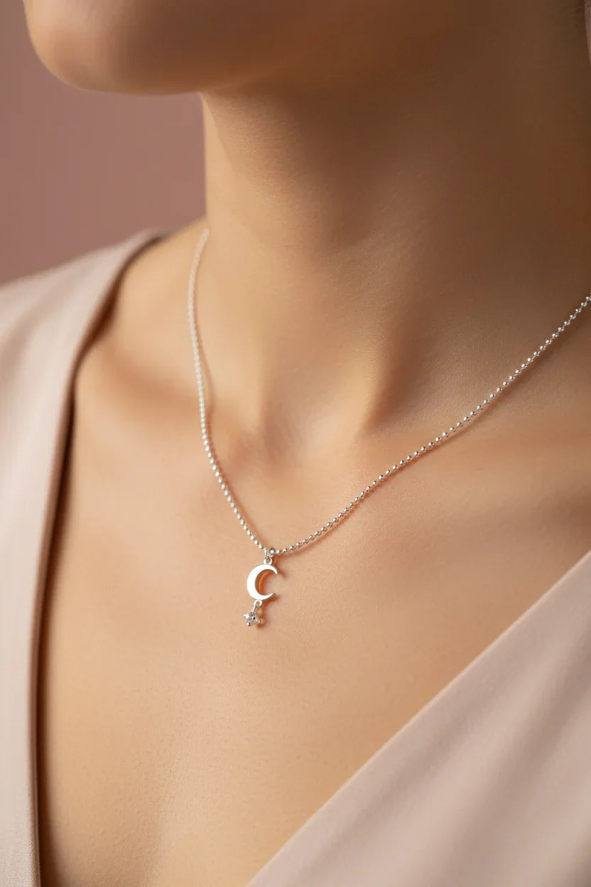 Silver chain necklace with crescent moon and star pendant on elegant neckline